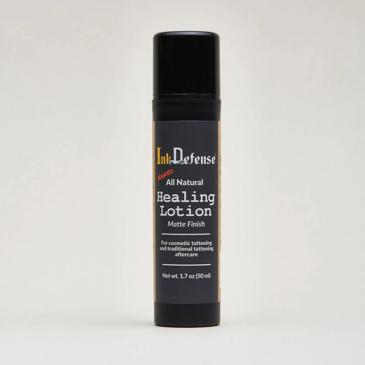 Black cylindrical bottle of ink defense all natural healing lotion with matte finish and gold accented label